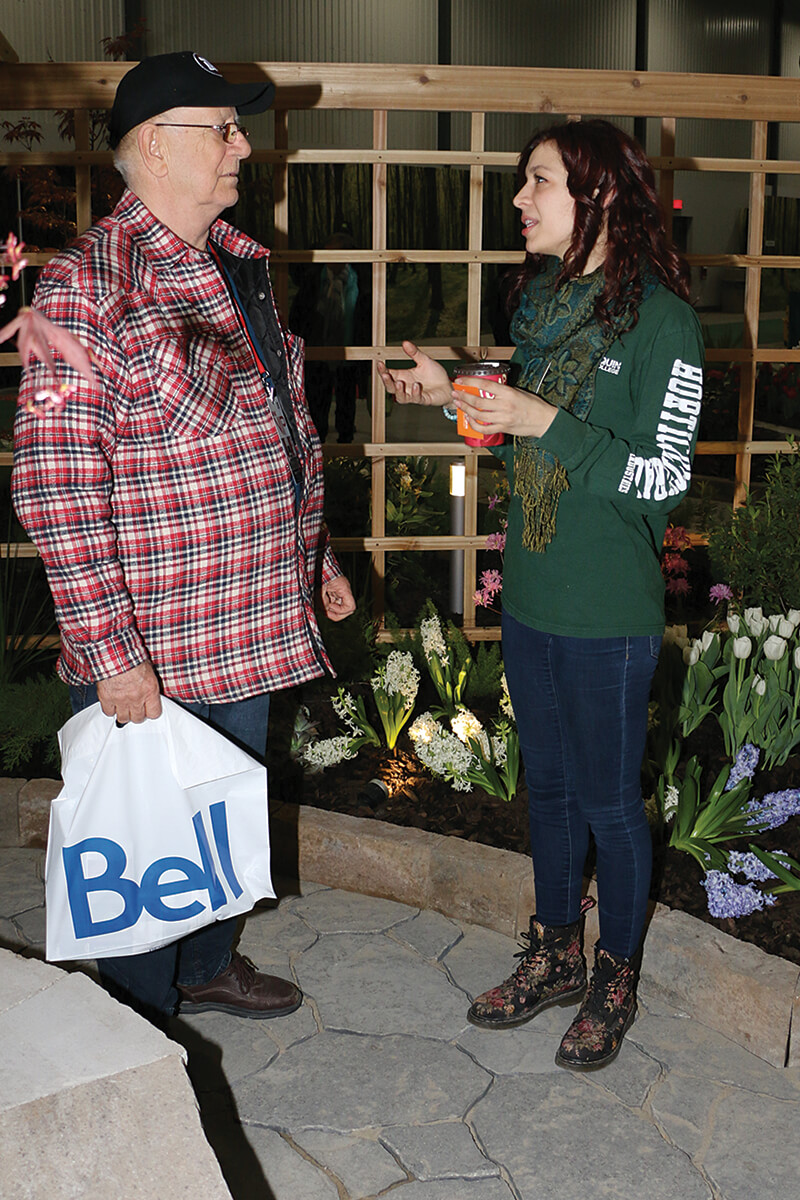 man and young girl talking in a feature garden inside the home show