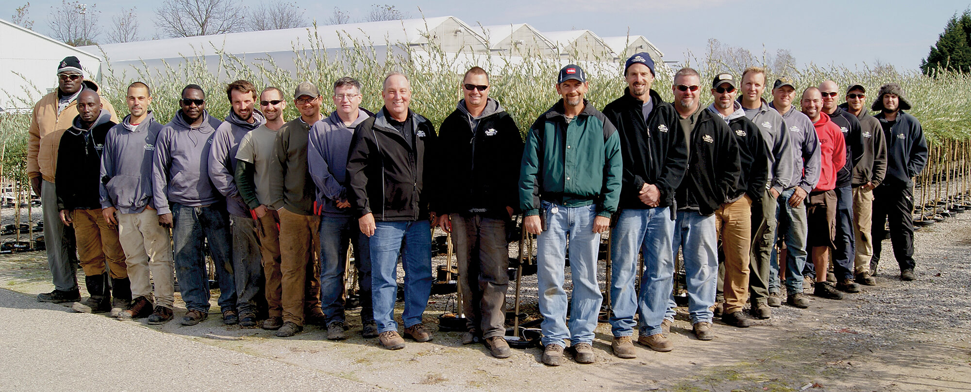 large group of workers standing in a nursery field